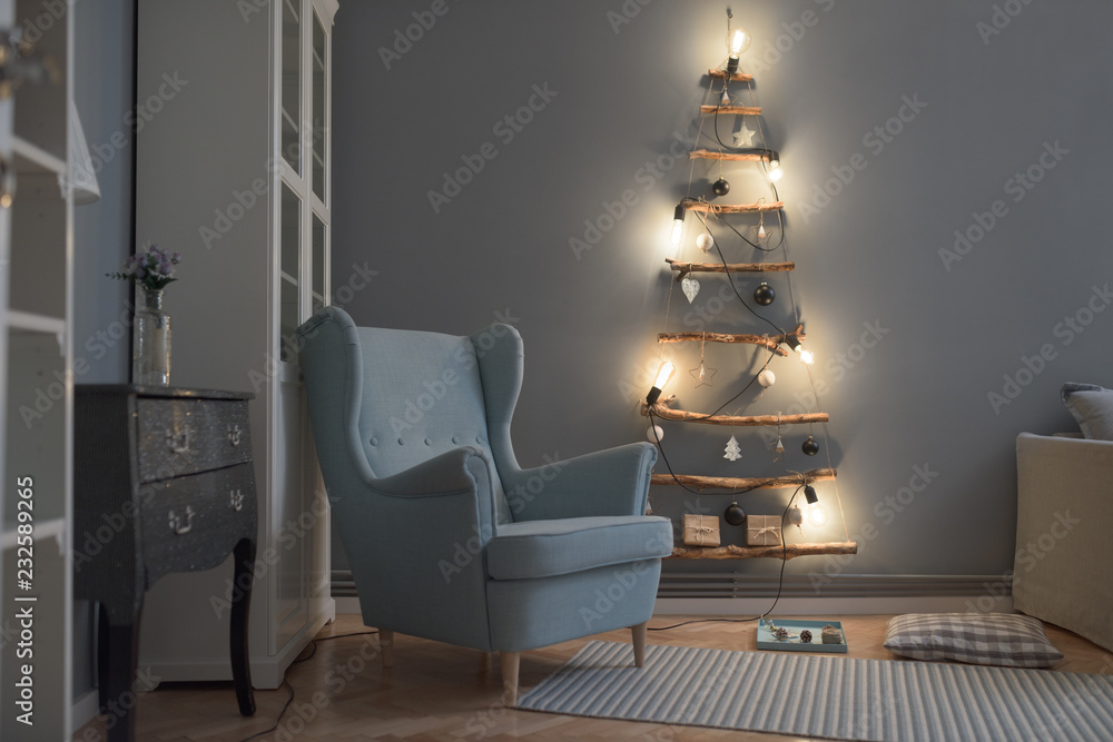 © Stocksy - Minimal handmade Christmas tree illuminated by warm light bulbs