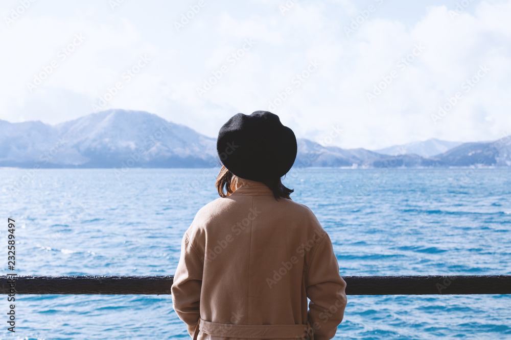Beautiful young woman looking at views of the lake and mountains winter in Japan Beautiful young woman looking at views of the lake and mountains winter in Japan