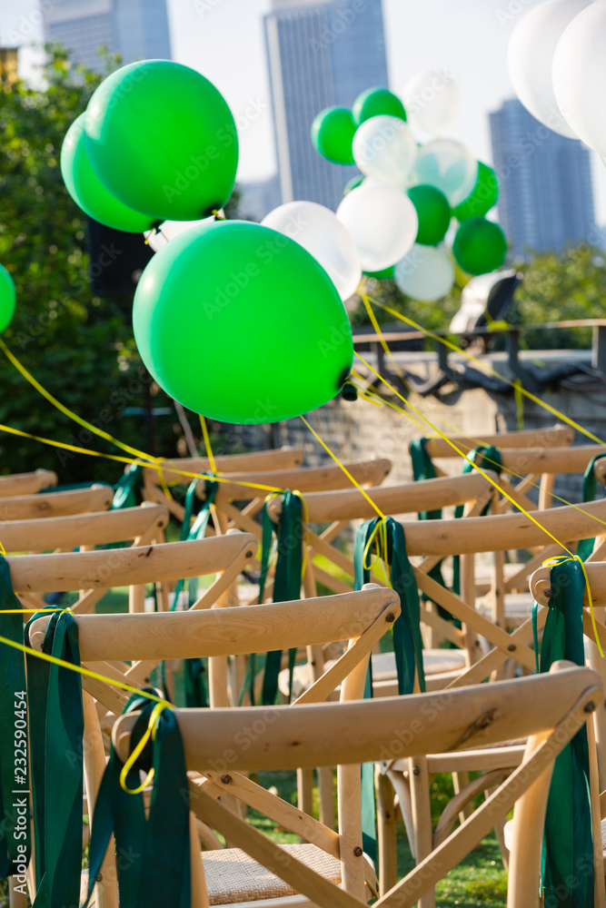 Chairs with white and green balloons were hung at the wedding