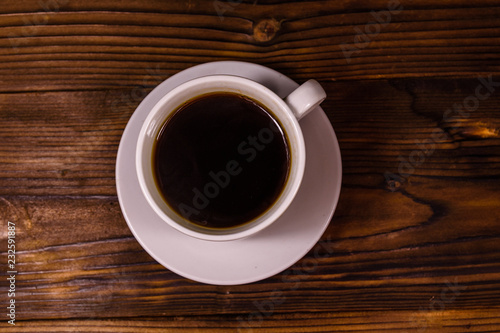 Cup of dark coffee on wooden table. Top view