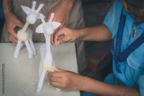 Students learn to make paper mache art as a giraffe in school. photo