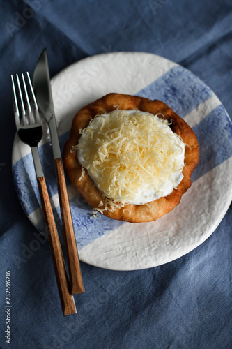 Langos (fried Hungarian flatbread with sour cream and grated cheese) photo