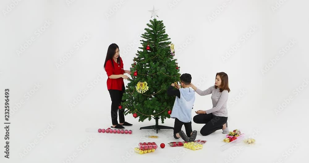 Lovely Asian family decorated Christmas tree by beautiful ornament together, concept for Christmas celebration. Lovely Asian family decorated Christmas tree by beautiful ornament together, concept for Christmas celebration.