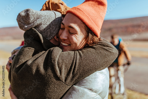 Friends hugging on an airfield after flying glider planes