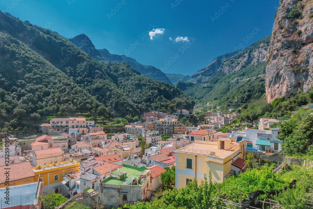 Houses of the town of Amalfi, Italy, under mountains and blue sky