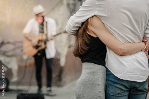 Couple in love listening street musician playing guitar