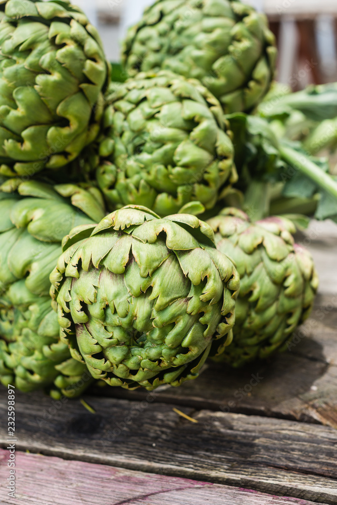 large artichokes on a wooden background large artichokes on a wooden background