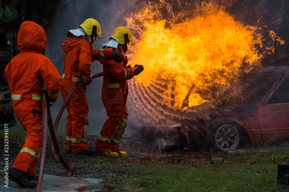 Back view of three Firefighters are injecting fire.