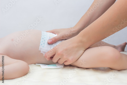 Girl changes a nappy to a small child, close-up, diaper replacement, copy space