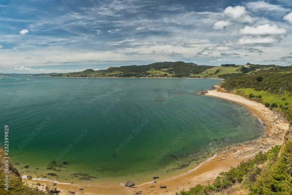 Panoramic view of the beach, white sand, blue water of the ocean and mountains and cloudy blue sky Panoramic view of the beach, white sand, blue water of the ocean and mountains and cloudy blue sky