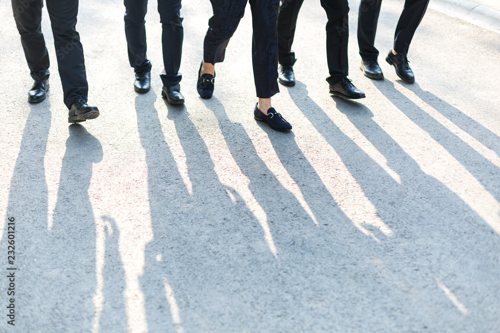 Obraz premium The sun shone on the five walking men,forming shadows on the road