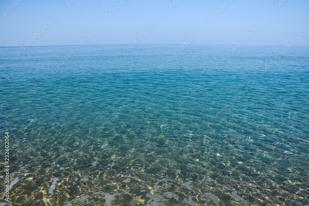 Tropical beach with turquoise clear water. Summer sandy beach with a blue sea water Tropical beach with turquoise clear water. Summer sandy beach with a blue sea water