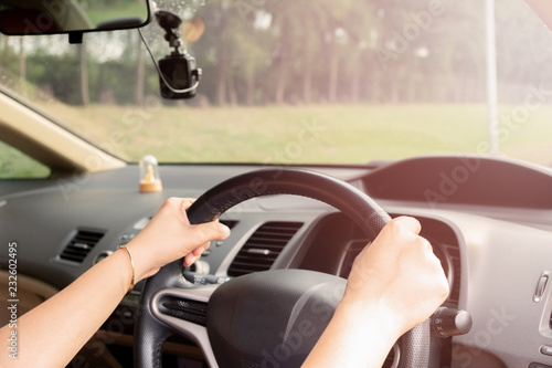 Woman's hands of a driver on steering wheel of a car