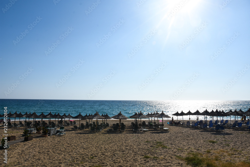 Beach umbrellas and sunbeds on Greece. Summer beach with parasols
