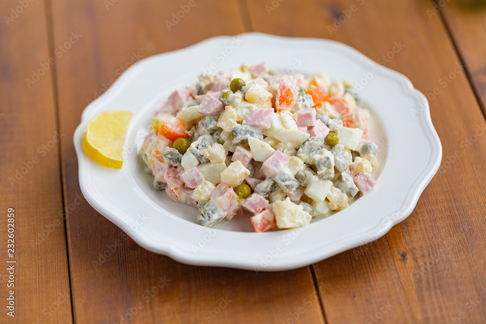 Traditional Russian salad on a wooden table Traditional Russian salad on a wooden table