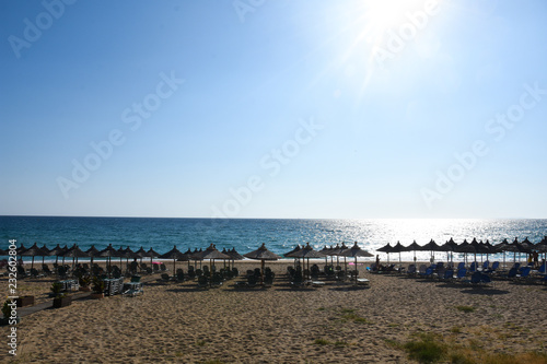 Fototapeta Naklejka Na Ścianę i Meble -  Beach umbrellas and sunbeds on Greece. Summer beach with parasols