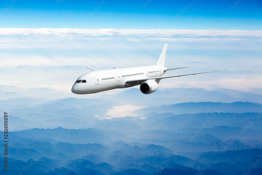 Passenger aircraft in flight. The plane flies over the mountains, covered with fogs. Front view of aircraft. Passenger aircraft in flight. The plane flies over the mountains, covered with fogs. Front view of aircraft.