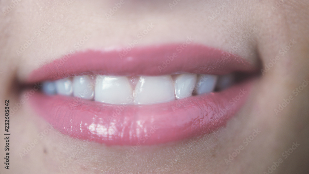 Close up of beautiful smiling pink lips of young girl with open mouth and teeth Close up of beautiful smiling pink lips of young girl with open mouth and teeth