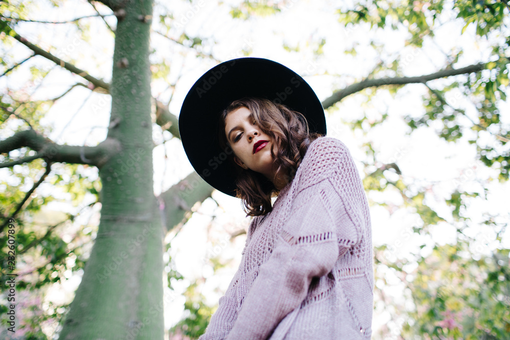 Beautiful woman near tree in park