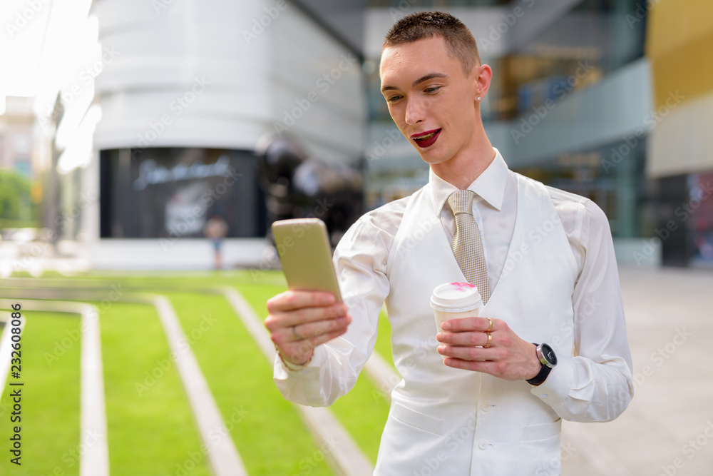 Young androgynous homosexual LGTB businessman using phone Young androgynous homosexual LGTB businessman using phone