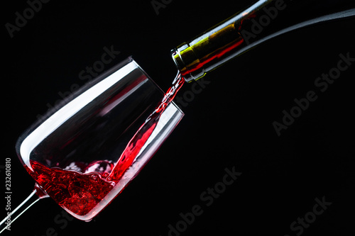 Red wine being poured into wineglass.