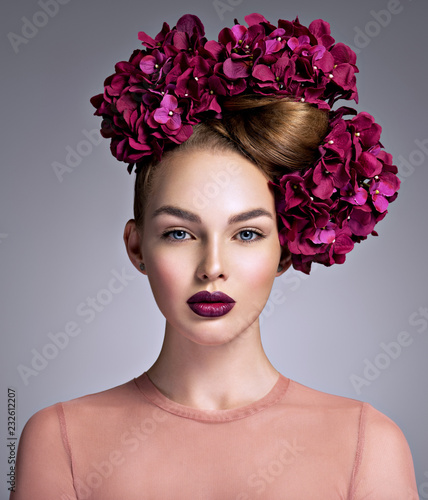 Young woman with a bouquet of purple flowers in her hair.