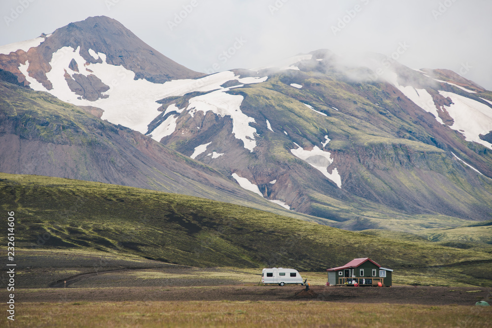 A mountain landscape with trailer and house A mountain landscape with trailer and house