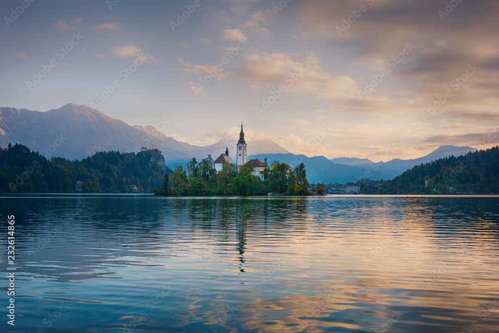 Beautiful sunrise landscape of famous mountain lake Bled in Slovenia with small church on green island