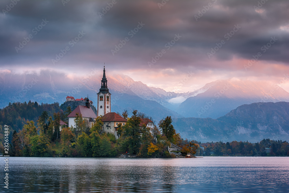 Beautiful sunrise landscape of famous mountain lake Bled in Slovenia with church on small green island