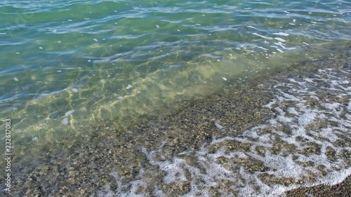Coarse sand beach on the shore of mongolian lake Durgen Nuur with clear transparent fresh water photo