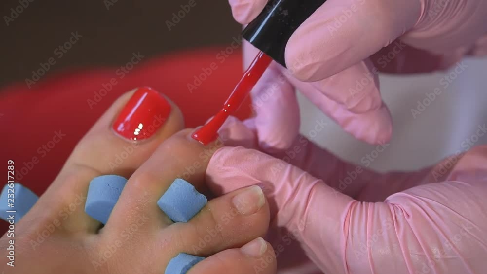 Pedicures in the salon. The master cares for the nails and feet of the client, doing the