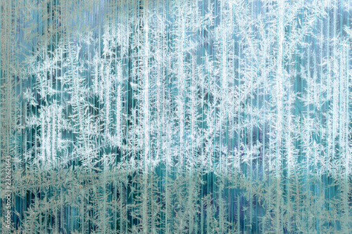 Frosty pattern of hoarfrost and snowflakes on striped glass, winter or Christmas background, texture