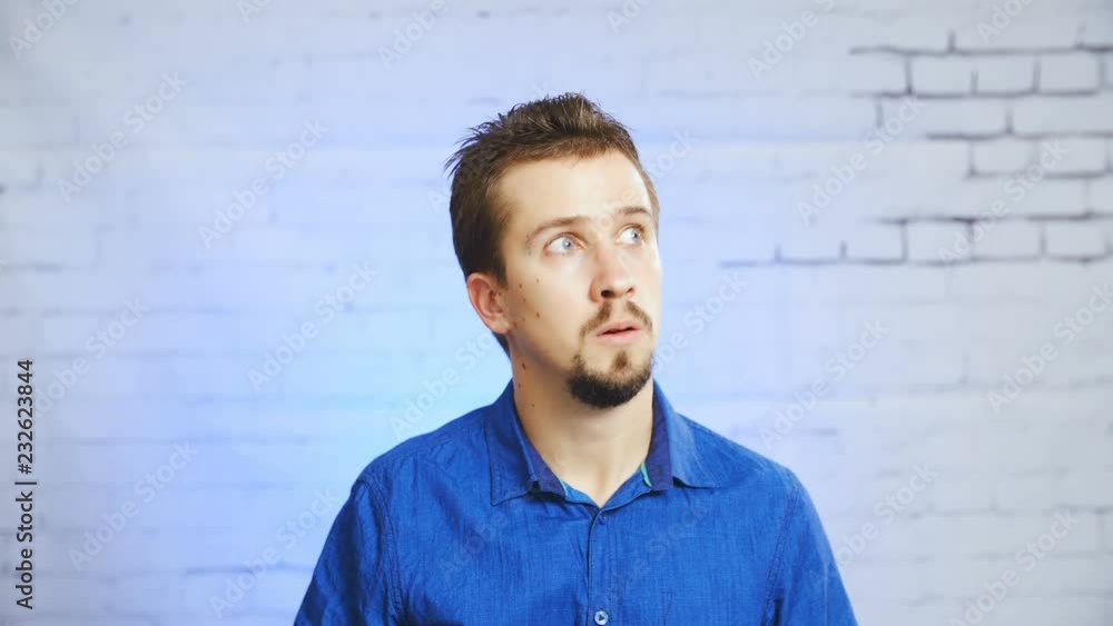 Paranoid person puts on the tin-foil hat meme 4K. Static portrait shot of a man in focus wearing a blue elegant shirt and a tin-foil hat, smiling into the camera. Paranoid person puts on the tin-foil hat meme 4K. Static portrait shot of a man in focus wearing a blue elegant shirt and a tin-foil hat, smiling into the camera.