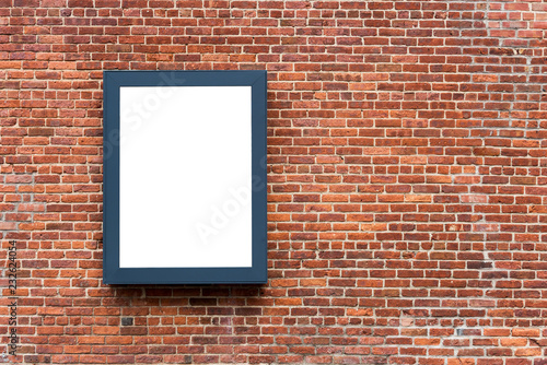 Blank advertising poster board on the brick wall on street..