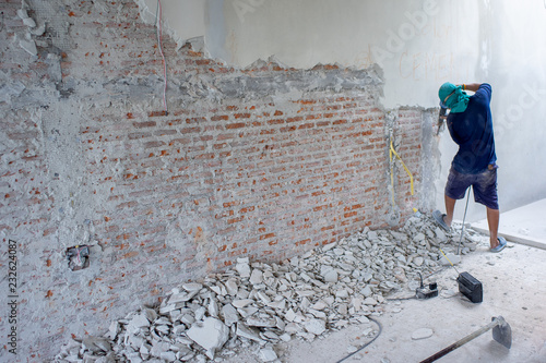 Canvas-taulu Portrait of worker using the drilling machine punching to the bricklayer wall at