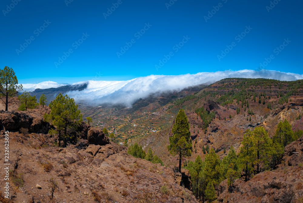 A sunny day with a blue sky and clouds walking over the mountains A sunny day with a blue sky and clouds walking over the mountains