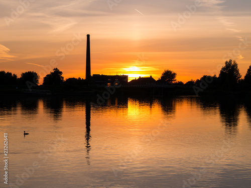 Waterfront silhouette of steam pumping station with museum at sunset, Medemblik, Netherlands