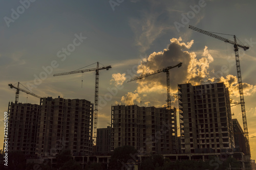 Cranes working day and night on construction of the housing estate in former industrial zone