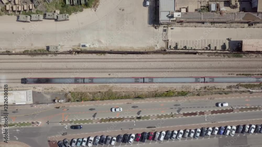 Following a modern passenger train along the tracks - Top down aerial footage Following a modern passenger train along the tracks - Top down aerial footage