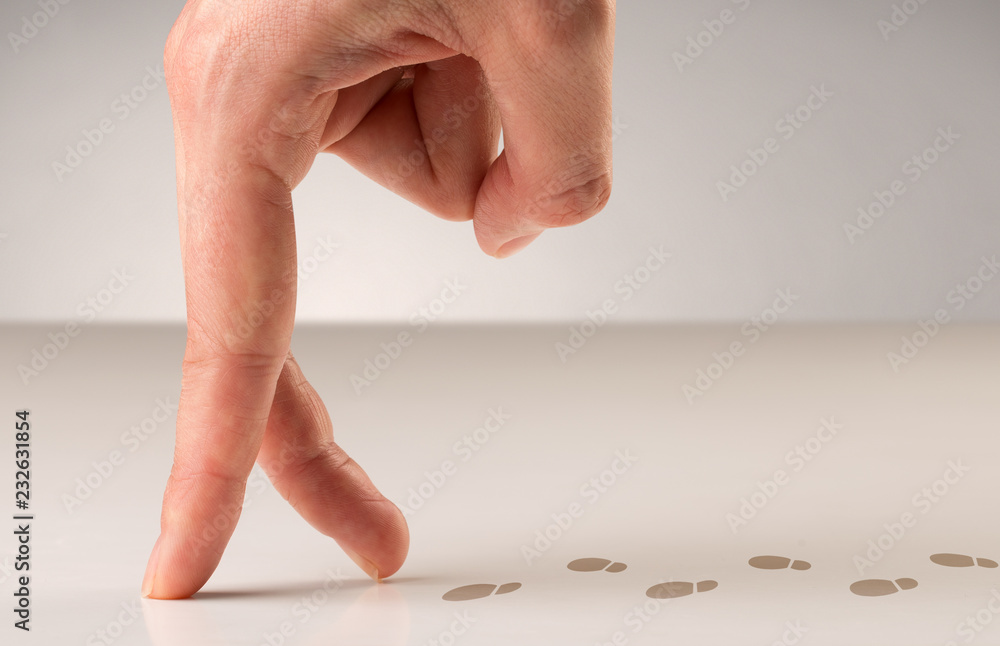 Female fingers walking on white surface with footsteps behind it Female fingers walking on white surface with footsteps behind it