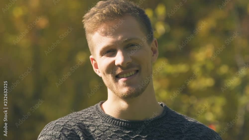 Young handsome man posing for camera in autumn park, happy and healthy life Young handsome man posing for camera in autumn park, happy and healthy life