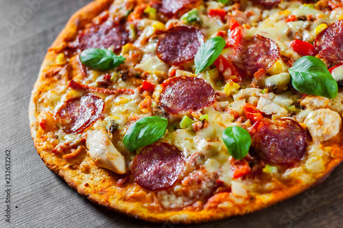 Pizza with Chicken meat, Mozzarella cheese, pepperoni, tomato, vegetables, salami. Italian pizza on wooden background