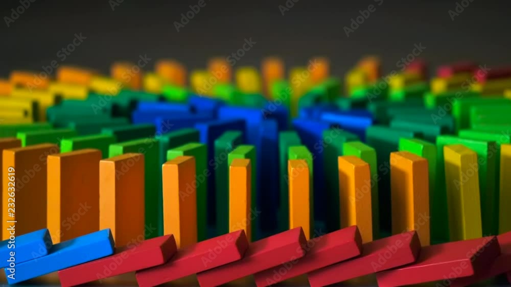 The domino effect of colorful wooden blocks, slow motion, selective focus The domino effect of colorful wooden blocks, slow motion, selective focus