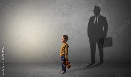 Little boy imagine that he will be businessman and illustrating his future in a big shadow 