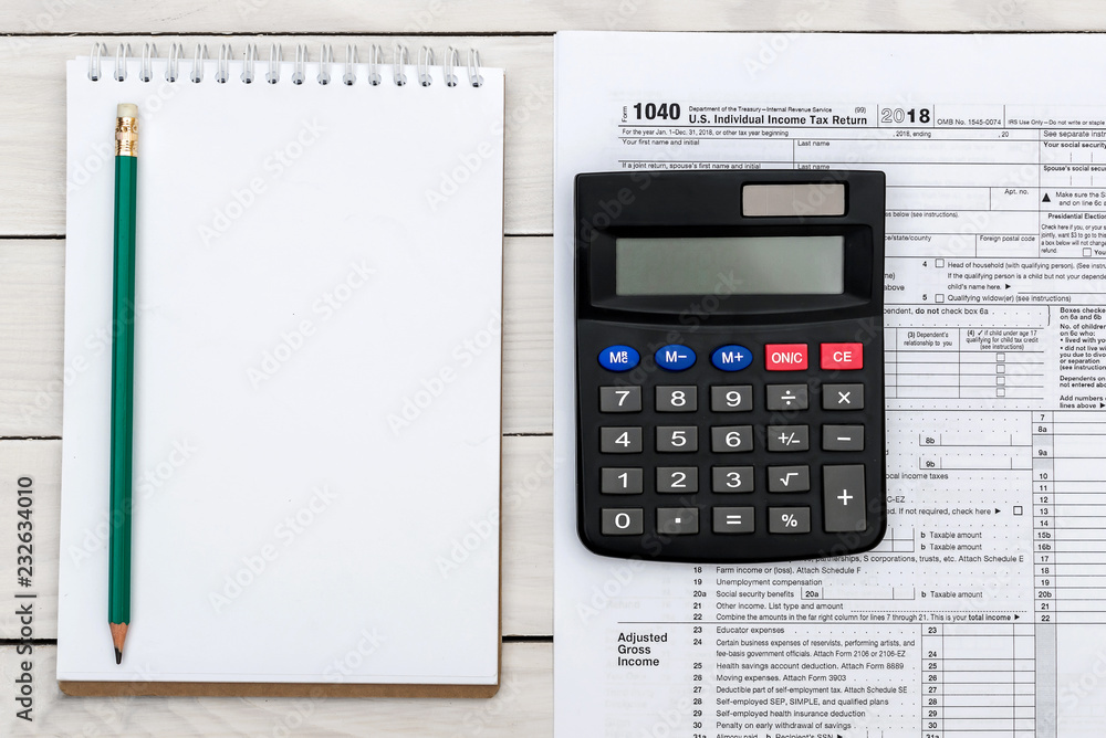 Blank notepad with tax form and calculator on white table. Top view. Space for text. Blank notepad with tax form and calculator on white table. Top view. Space for text.