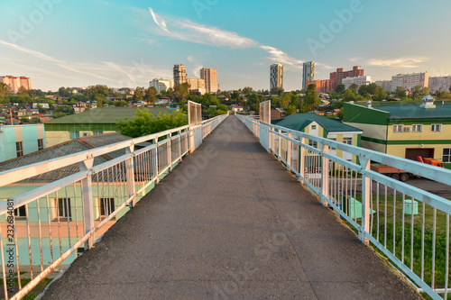 Pedestrian viaduct. Beautiful perspective on background of city blue cloudy sunset sky © EVGENII