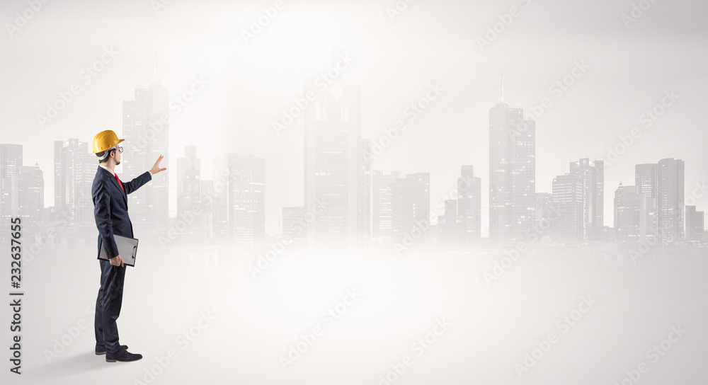 Young supervisor architect standing and looking at a big city panorama
Young supervisor architect standing and looking at a big city panorama