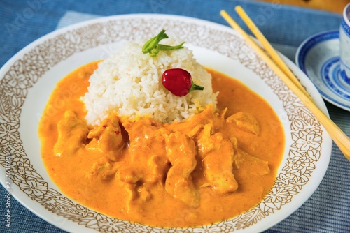 Chicken meat in mango sauce, rice on white plate with chopsticks .