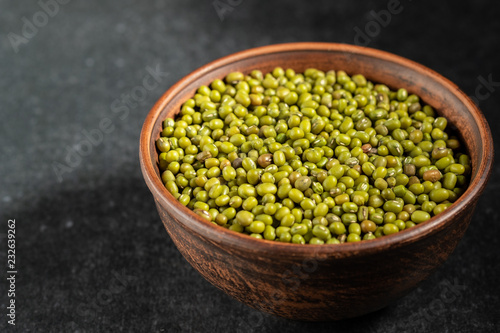 fresh mung beans in ceramic dishes against a dark stone background photo