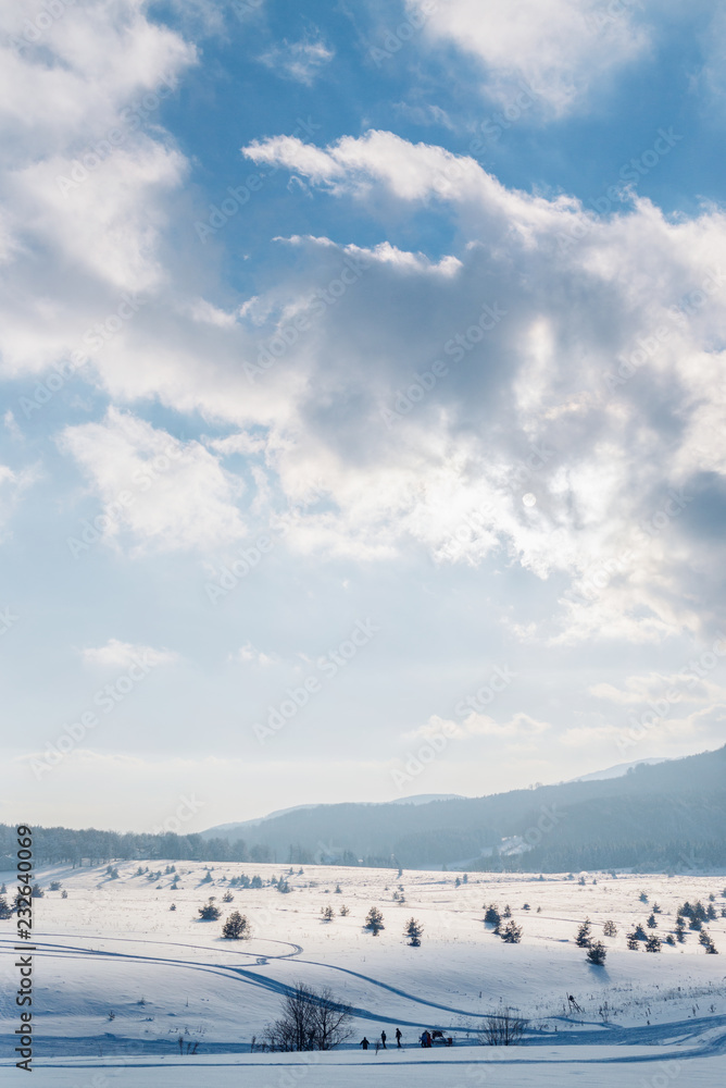 Beautiful winter mountain scenery with unrecognizable skiers Beautiful winter mountain scenery with unrecognizable skiers